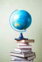 Free photo mountain of books with a globe