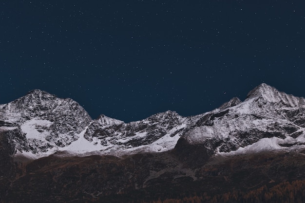 Foto gratuita montagna coperta di neve durante la notte