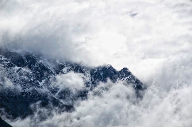 Foto gratuita paesaggio di montagna con nebbia e cielo nuvoloso