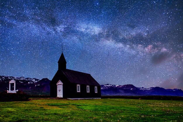 마운틴 뷰 아이슬란드. 환상적인 별이 빛나는 하늘과 은하수. Budir에서 아름 다운 검은 목조 교회