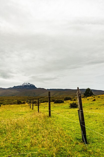 Mountain with snow on its summit with a cloudy sky over it