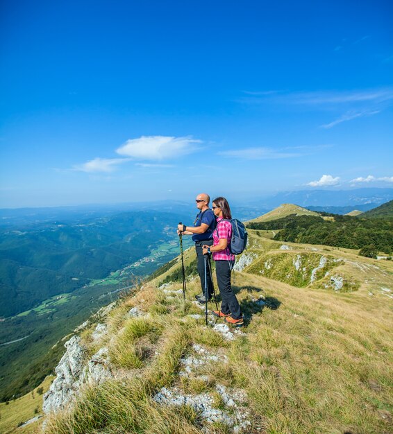 Mountaineer couple on the Nanos plateau in Slovenia looking at the beautiful Vipava Valley