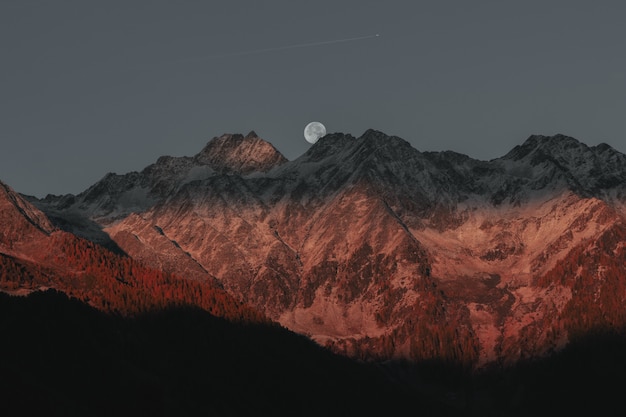 満月の背後にある山