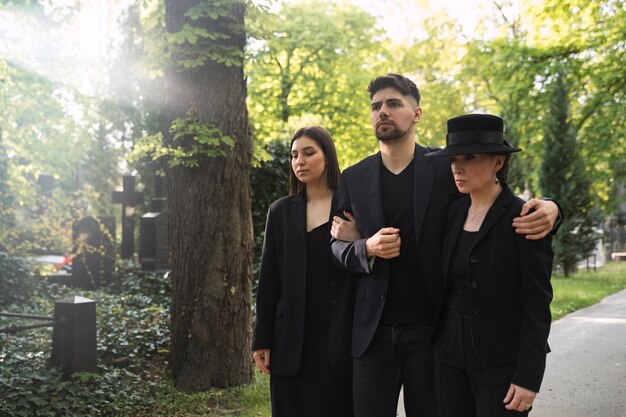 mourning family dressed in black visiting the cemetery