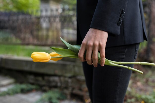 mourning man bringing tulips at the cemetery