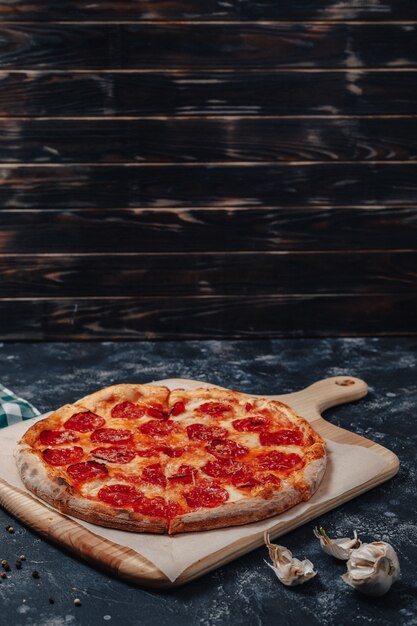 Mouth-watering Neapolitan pizza on a blackboard with various ingredients, free space for text