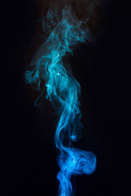 Movement of transparent blue smoke on dark black background