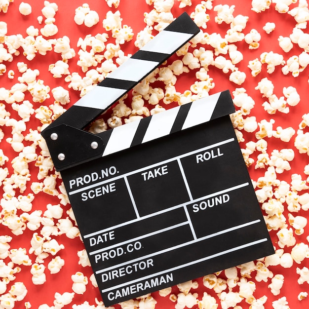 Free photo movie clapper on red background with popcorn all around