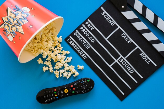 Movie concept with popcorn, clapperboard and remote control