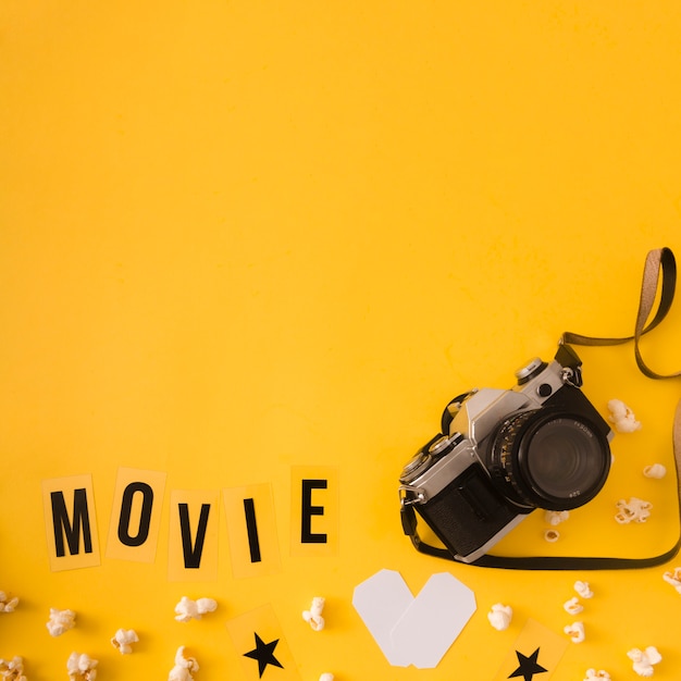 Free photo movie lettering on yellow background with copy space