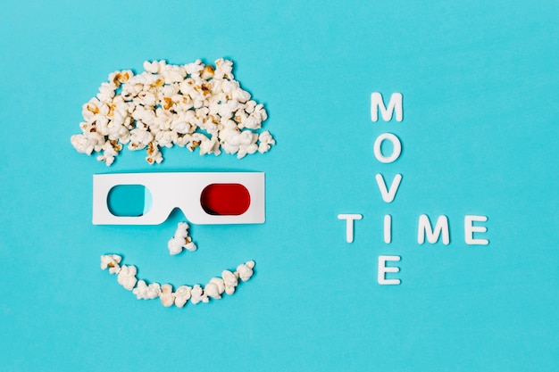 Foto gratuita testo del film con faccina antropomorfa sorridente realizzato con popcorn e occhiali 3d