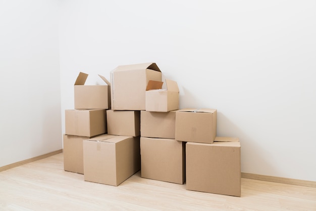 Moving cardboard boxes on the corner of new room