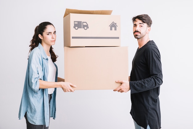 Moving concept with couple carrying two boxes