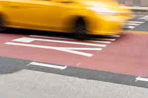 Бесплатное фото Движущаяся желтая машина по городу