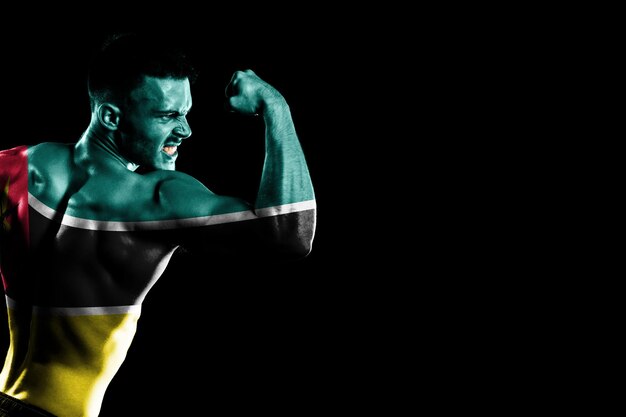 Mozambique flag on handsome young muscular man black background