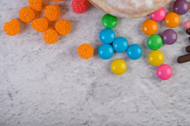 Foto gratuita molte caramelle multicolori disposte su una superficie bianca.