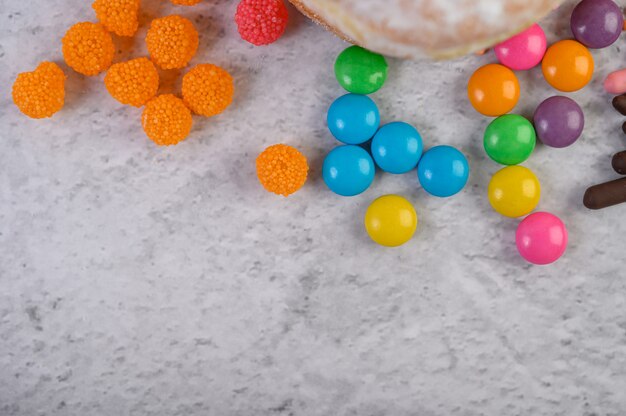 Much multicolored candies placed on a white surface.