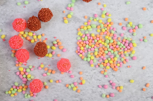 Free photo much multicolored candies placed on a white surface.