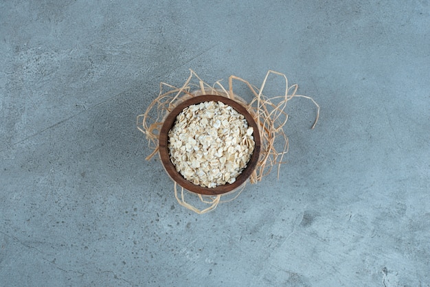 Muesli grains in a wooden cup on blue background. High quality photo