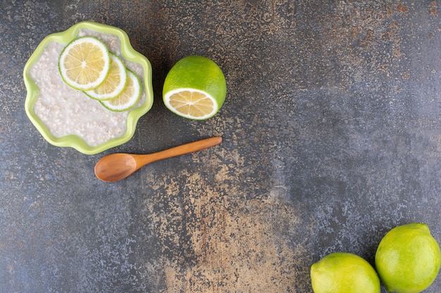 Foto gratuita porridge di muesli con fette di limone in un piatto verde