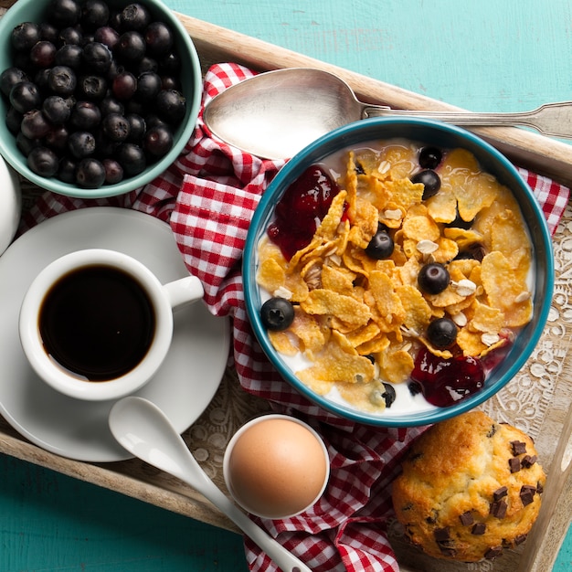 Foto gratuita muesli con frutti di bosco e caffè sul vassoio