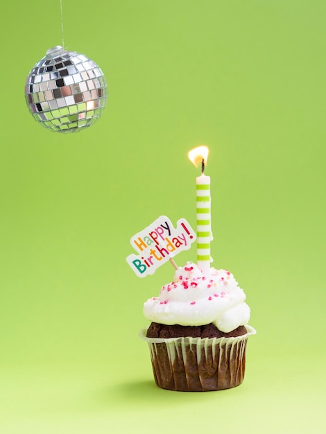 Free photo muffin with candle disco globe and happy birthday sign