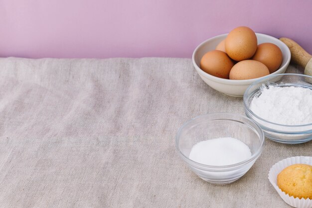 Muffin with ingredients on tablecloth