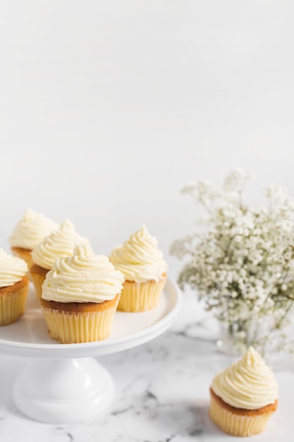 Muffins on cake stand against white background