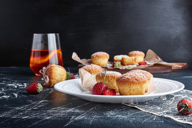 Muffins in a white plate with berries around. 