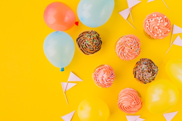 Free photo muffins with sprinkles amidst balloons