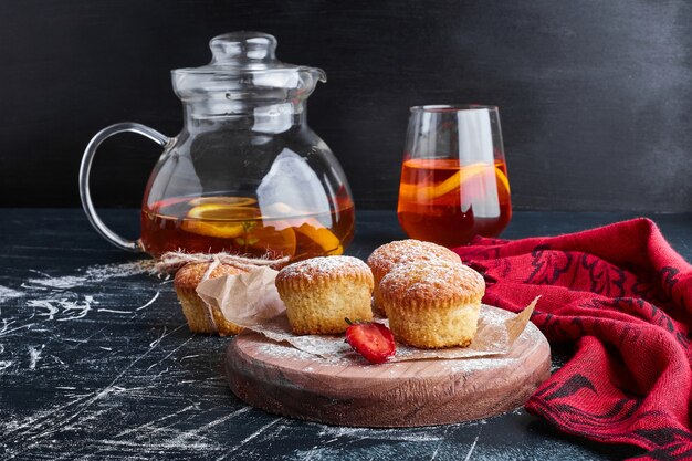 Muffins on a wooden board with a glass of drink. 