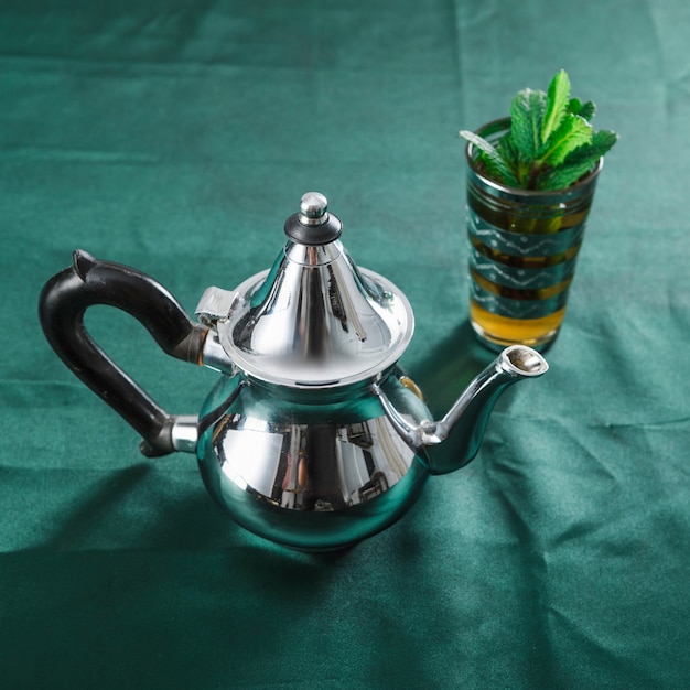 Mug of drink and silver teapot