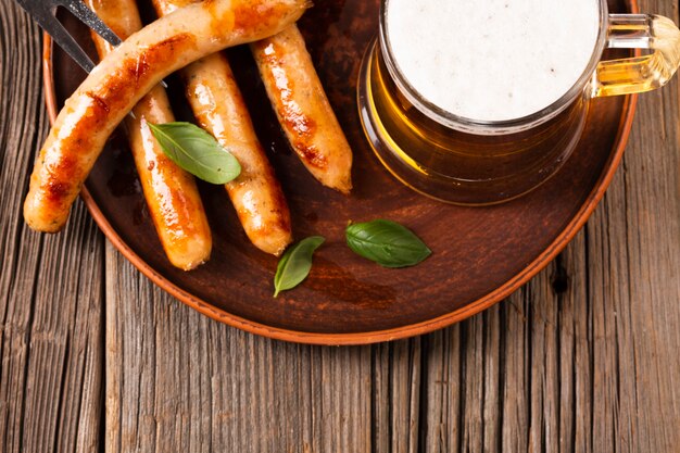 Mug and sausages on wooden background