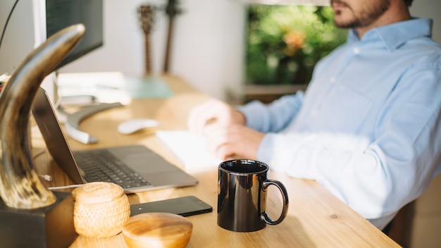 Mug standing near working man