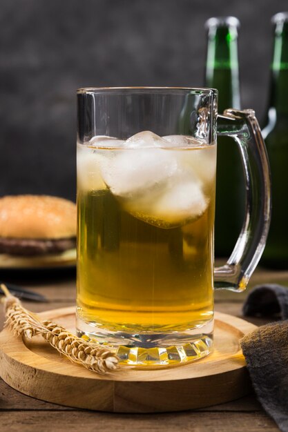 Mug with beer and hamburger beside