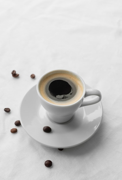 横にコーヒーとコーヒー豆のマグカップ