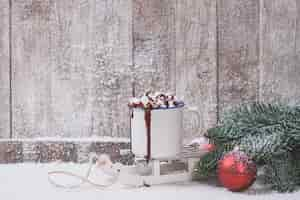 Free photo mug with marshmallows and christmas decorations