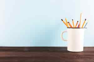 Free photo mug with pencils and ruler on table