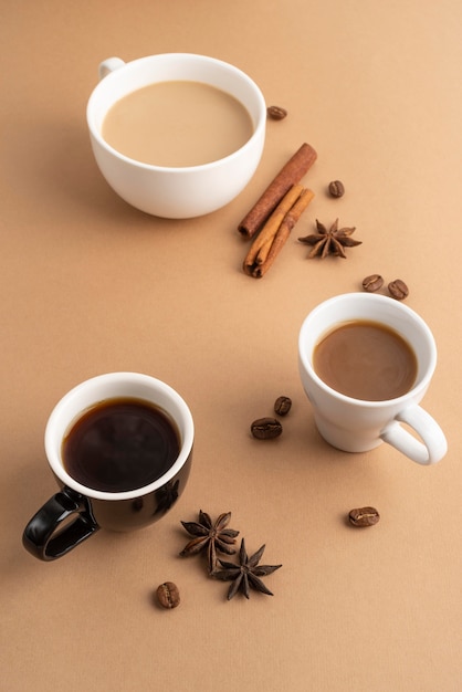 Mugs with coffee with cinnamon and anise beside