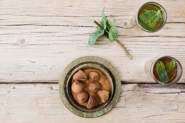 Free photo mugs with plant twigs and chocolate sweets on board