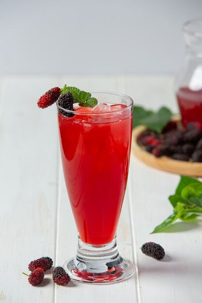 Mulberry juice on white wooden surface