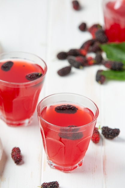 Mulberry juice on white wooden surface