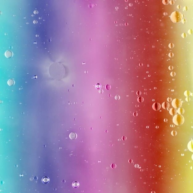 Multi colored background with oil bubbles floating on water surface