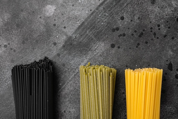 검은색 짙은 석재 테이블 배경 상단 보기 평면에 재료가 설정된 다양한 색상의 스파게티와 텍스트 복사 공간