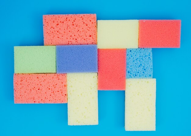 Multi colored sponges on blue background