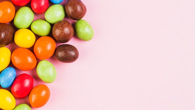 Multi colored sweet candies on pink background