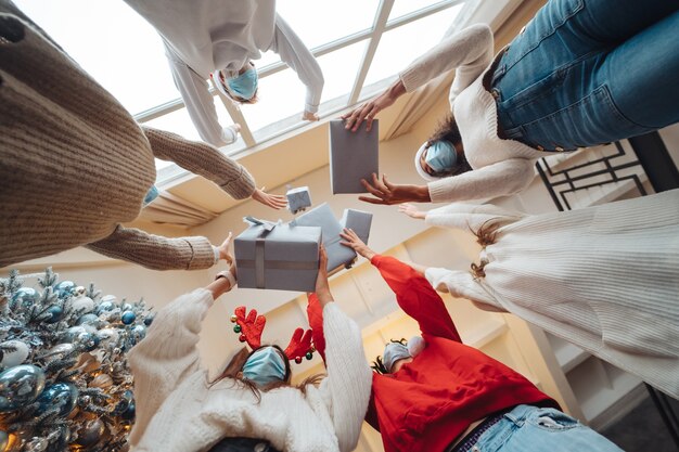 Multi-ethnic friends throwing their Christmas gifts in the air.