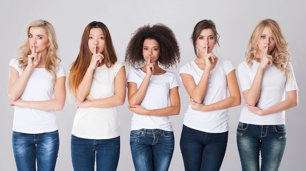 Multi ethnic women with silence sign 
