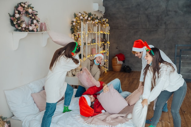 Multi-ethnic young people have fun fighting on pillows on new year's eve