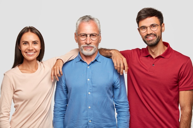 Free photo multi generation concept. family portrait of mature wrinkled man dressed in stylish shirt, stands between his daughter and son